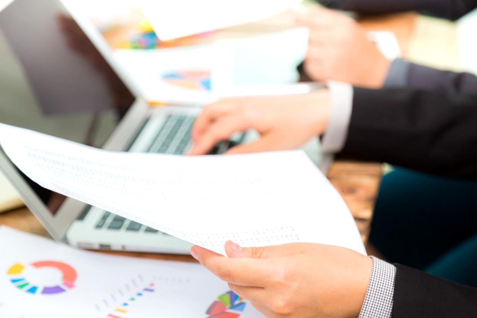 Рабочее место финансового аналитика с документами и компьютером